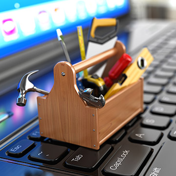 une boite à outil miniature posée sur un clavier d'ordinateur