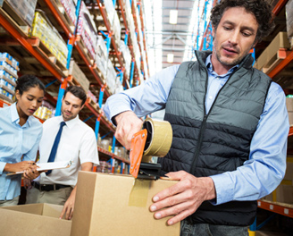 un manutentionnaire dans un entrepôt ferme un carton
